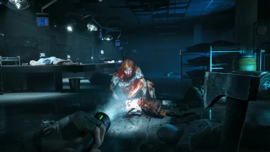 A player with a flashlight and axe faces a zombie in a dim morgue